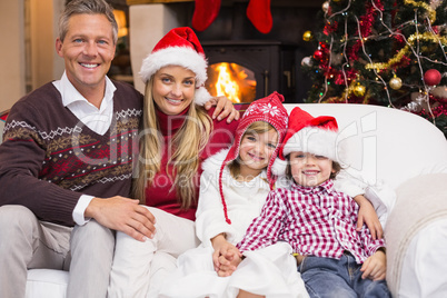 Portrait of a smiling family sitting on sofa at christmas time