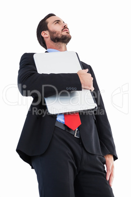 Concentrating businessman in suit holding laptop
