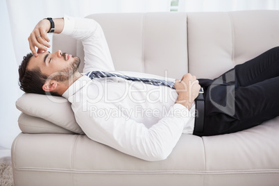 Businessman lying on couch after long day