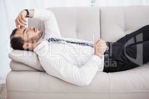 Businessman lying on couch after long day