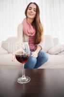 Pretty brunette drinking wine on couch