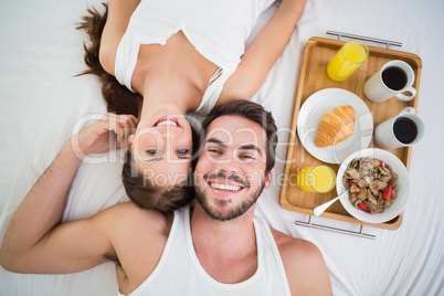 Young couple having breakfast in bed