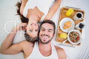 Young couple having breakfast in bed