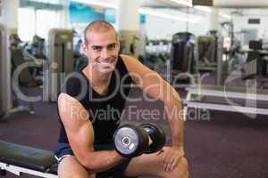 Portrait of man exercising with dumbbell in gym