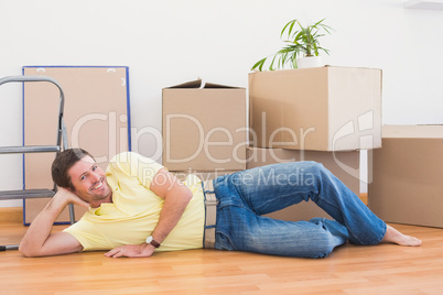 Happy man posing with moving boxes at home