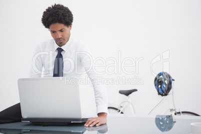 Serious businessman sitting and using laptop