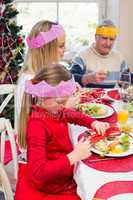 Little girl in party hat holding christmas crackers