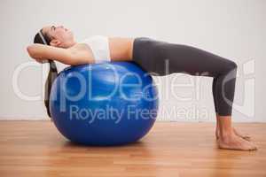 Fit brunette working out with exercise ball