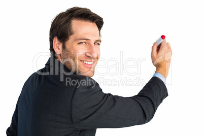 Businessman standing and writing while looking at camera