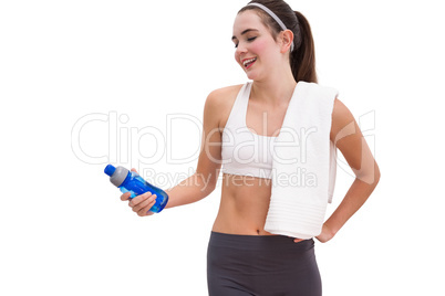 Fit brunette looking at sports bottle