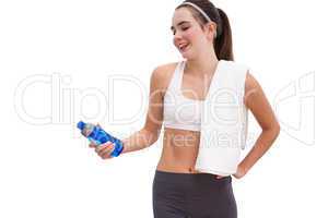 Fit brunette looking at sports bottle