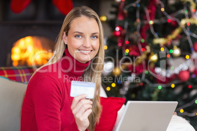 Blonde shopping online with laptop at christmas