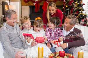 Multi generation family opening presents on sofa