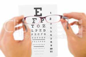 Glasses held up to read eye test