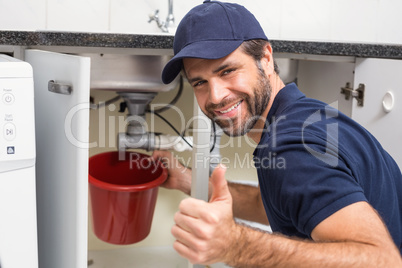 Plumber fixing under the sink