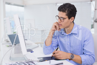 Casual graphic designer working at his desk