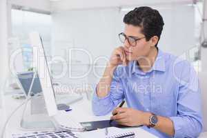 Casual graphic designer working at his desk