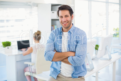 Portrait of handsome smiling photo editor with arms crossed