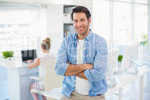 Portrait of handsome smiling photo editor with arms crossed