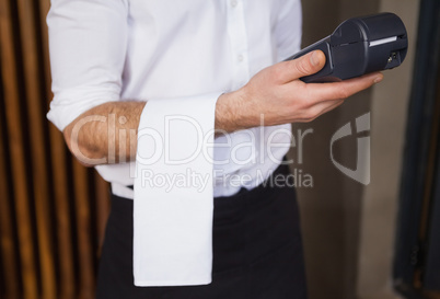 Handsome waiter holding credit card machine