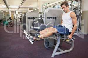 Fit man using weights machine for legs