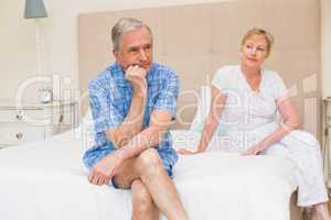 Senior couple not speaking after an argument on bed