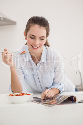 Pretty brunette eating bowl of cereal