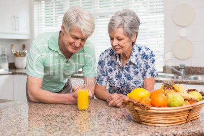 Senior couple looking at glass of orange juice