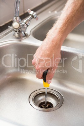 Man fixing sink with screwdriver