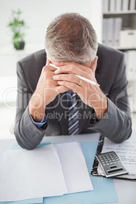 Stressed businessman with head in hands