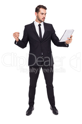 Focused businessman holding pen and notebook
