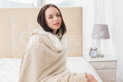 Pretty brunette sitting on bed