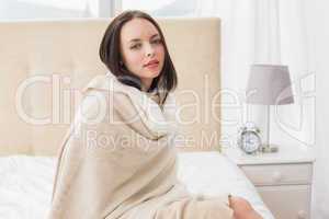 Pretty brunette sitting on bed