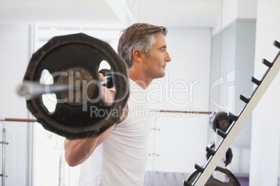 Fit man lifting heavy barbell