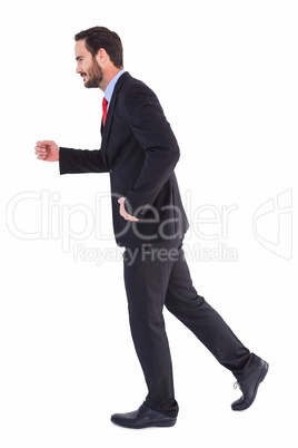 Smiling businessman stepping with hands raised