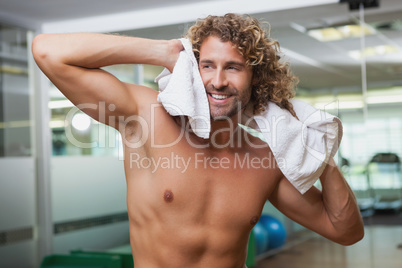 Happy shirtless man standing in gym