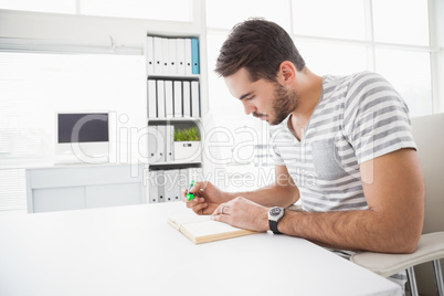 Casual businessman highlighting a book