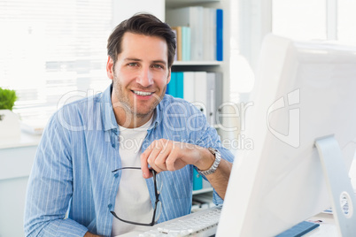 Editor working at his computer while looking at camera