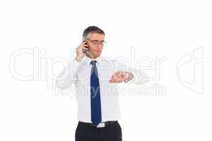 Businessman on the phone looking at his wrist watch