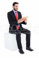 Thoughtful businessman sitting reading book