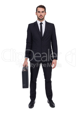 Serious businessman posing and holding briefcase