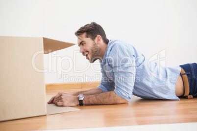 Smiling man looking inside cardboard box