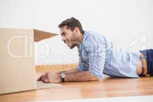 Smiling man looking inside cardboard box