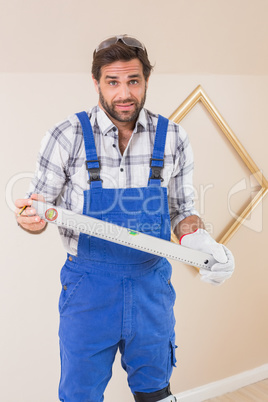 Confused construction worker holding spirit level