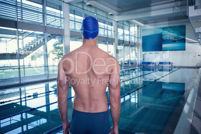 Rear view of shirtless swimmer by pool at leisure center