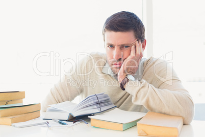 Bored casual businessman studying at his desk