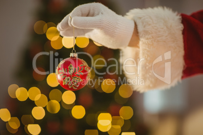 Hand of santa holding a bauble