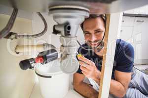 Plumber fixing under the sink