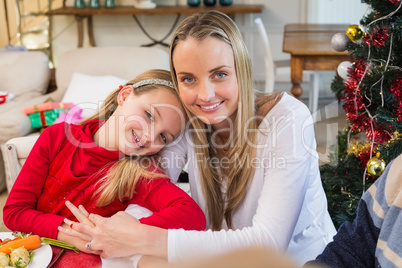 Festive mother and daughter smiling at camera