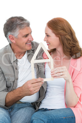 Casual couple holding house outline